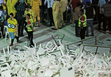 Security guards stand around a pile of plastic chairs and tables  Security guards stand around a pile of plastic chairs and tables to illustrate Australian research review urges action on time wasting, interference