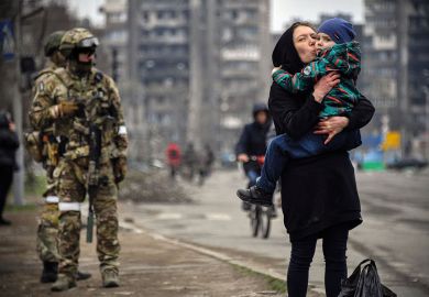  A woman holds and kisses a child next to a Russian soldier to illustrate Upsurge in defence research awakens disciplinary divisions