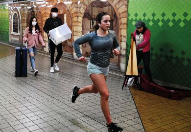 Student running by others wearing face masks to illustrate Splash overseas fee cash back on students, Australia urged