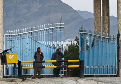 Taliban fighters stand guard at the main gate of Laghman University in Mihtarlam to illustrate Afghan scholars fear creeping closure of universities