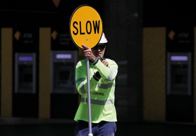 A traffic control worker holds a traffic sign reading "Slow" in Brisbane, Australia A traffic control worker holds a traffic sign reading "Slow" in Brisbane, Australia to illustrate Visa chaos ‘latest driver’ of ‘two-tiered Australian sector’
