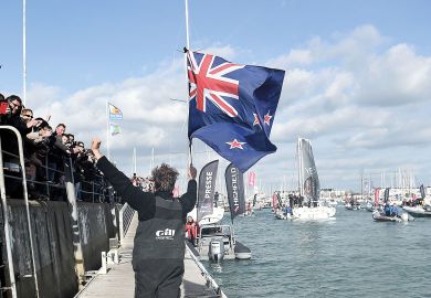 Man, holding a New Zealand national flag, greeting supporters to illustrate Branch campuses ‘not the way forward’ for New Zealand