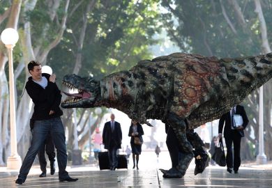 A Tyrannosaurus rex takes a morning stroll with commuters in Hyde Park n Sydney, Australia to illustrate Students protest against ‘predatory’ scholarship revocations