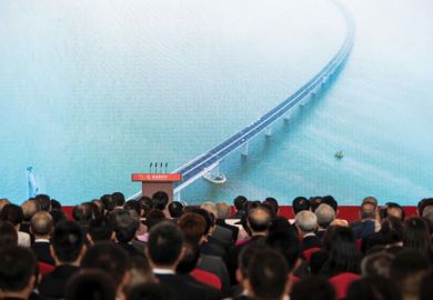 Guests watch a trailer on a giant screen during the opening ceremony of the Hong Kong-Zhuhai-Macau Bridge 