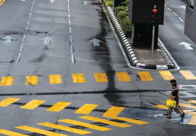 Pedestrian crossing at the intersection in downtown Kuala Lumpur to illustrate Careers advice for international students ‘misdirected’