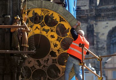 Worker removes the calendar dial of Prague's medieval astronomical clock  to illustrate Feared Czech institute takeover risks ‘incompetent interference’