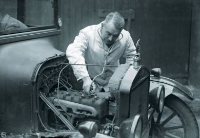 A motor mechanic listens to a car engine with a stethoscope.