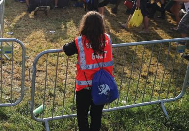 Security person holding gate at a festival