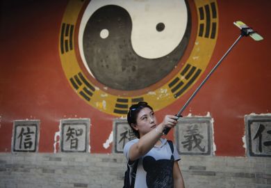 A tourist takes a selfie stick while visiting an ancient palace in China A tourist takes a selfie stick while visiting an ancient palace in China