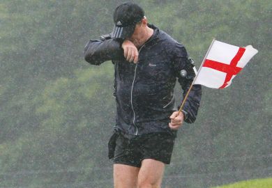 Man  soaking wet as he runs through Wiltshire holding a St Georges Flag.