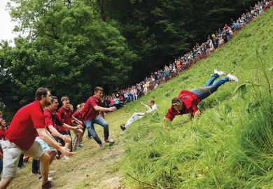 a competitor comes tumbling down the hill during the cheese rolling competition near the village of Brockworth, Gloucester, in western England a competitor comes tumbling down the hill during the cheese rolling competition near the village of Brockworth, Gloucester, in western England
