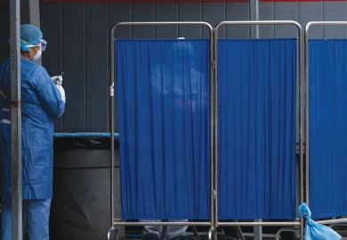 A man is tested behind a screen at the General Hospital 