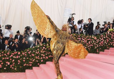 on the red carpet person wearing huge gold sparkle angel wings on the red carpet person wearing huge gold sparkle angel wings