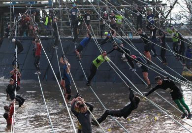 Participants climb ropes over water  Participants climb ropes over water to illustrate English economic model ‘unravelling’ as more students miss out