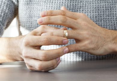 A man removes his wedding ring, symbolising exclusive partnerships A man removes his wedding ring, symbolising exclusive partnerships