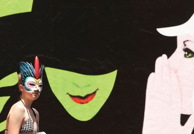 Woman passes Wicked billboard