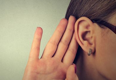 Woman cupping hand to ear to listen Woman cupping hand to ear to listen