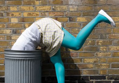 Woman diving into dustbin on street