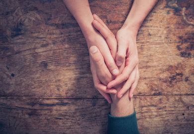 Woman holding man's hand providing support/kindness