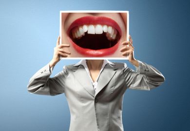 Woman holding photo of open mouth over face
