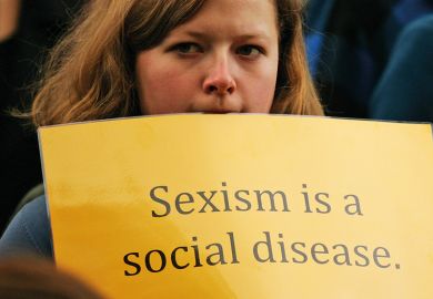Woman holding sexism is a social disease sign