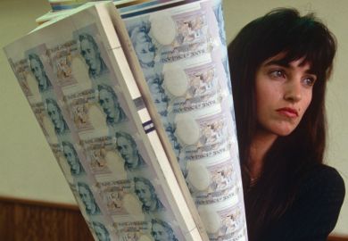 Woman holding sheets of uncut £5 banknotes, Bank of England printing works Woman holding sheets of uncut £5 banknotes, Bank of England printing works