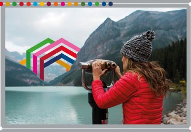 Woman looking through binoculars towards the Times Higher Education SDG icon embedded in the scenery, Canada. To illustrate assessing SDG engagement.