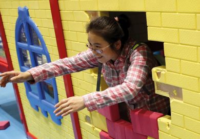 Woman playing with son at indoor playground, Beijing, China, 2015 Woman playing with son at indoor playground, Beijing, China, 2015