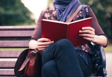 Woman reading on park bench