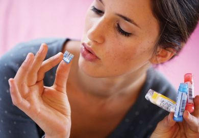 Woman taking homeopathic medicine Woman taking homeopathic medicine