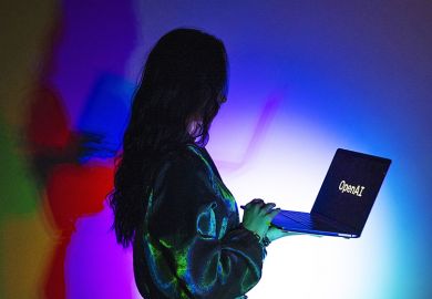 A woman looks at a laptop screen displaying the logo of 'OpenAI', to illustrate that academics question the pedagogical impact of AI learning assistants.