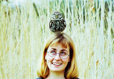 A woman with an owl balanced on her head A woman with an owl balanced on her head