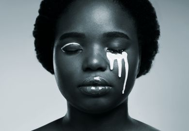 Black woman with white paint on her face to illustrate issue of diversity Black woman with white paint on her face to illustrate issue of diversity