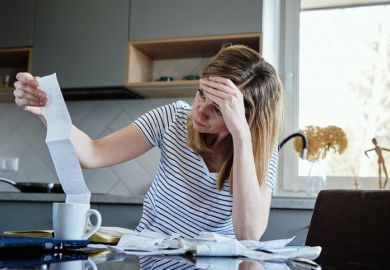 Woman calculating payment bill in kitchen