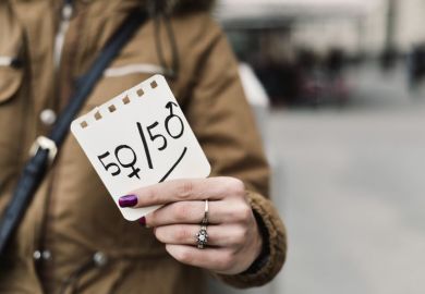 Woman holding up 50 50 gender sign Woman holding up 50 50 gender sign