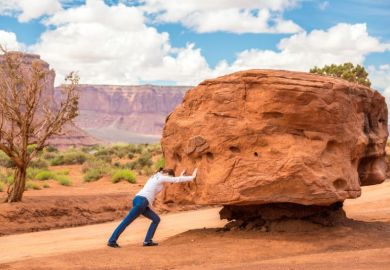 Woman pushing large stone