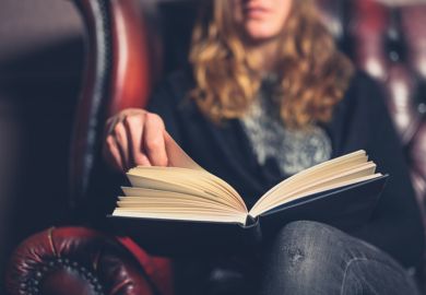A woman reading in an armchair illustrating book reviews, best books of the month