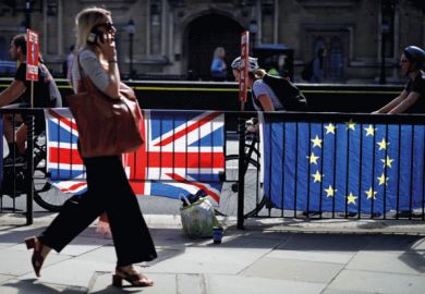 Woman walking past UK and EU flags Woman walking past UK and EU flags