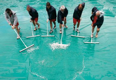 Workers remove water from court, French Open tennis tournament, Paris