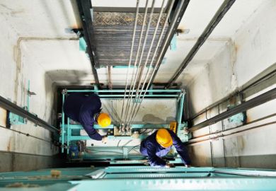 Workmen repairing a lift Workmen repairing a lift