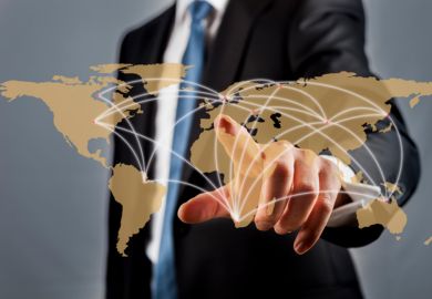 A businessman viewing a world map with key cities connected by dots A businessman viewing a world map with key cities connected by dots