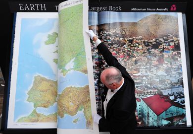 A man turns pages of what he calls "the world's largest book". To illustrate that the price of journal access agreements are becoming too big for universities after several publishers keep raising prices.