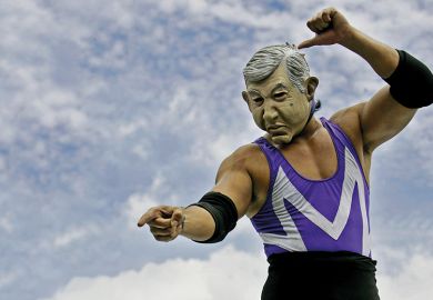 A wrestler in a mask points at something A wrestler in a mask points at something