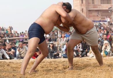 Wrestlers locked together Wrestlers locked together symbolising pushback on university boards