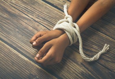 A person’s wrists bound with a rope A person's wrists bound with a rope, symbolising the restriction of academic freedom