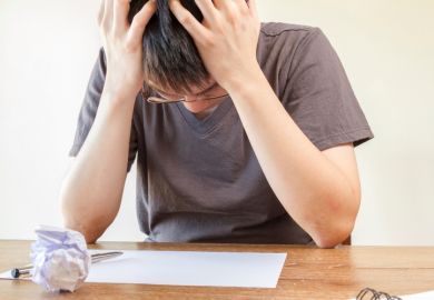Student holding head in hands
