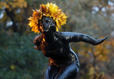 A statue with a crown of yellow leaves