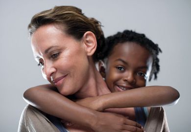 Young girl holding on to woman's back