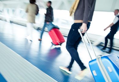 Young male student walking to airport departure lounge