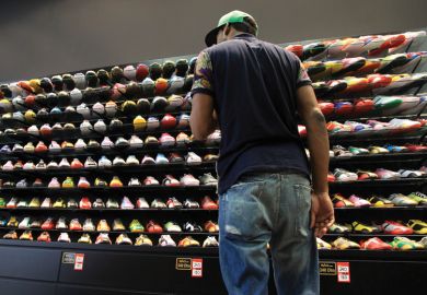 Young man looking at store display of sneakers/trainers